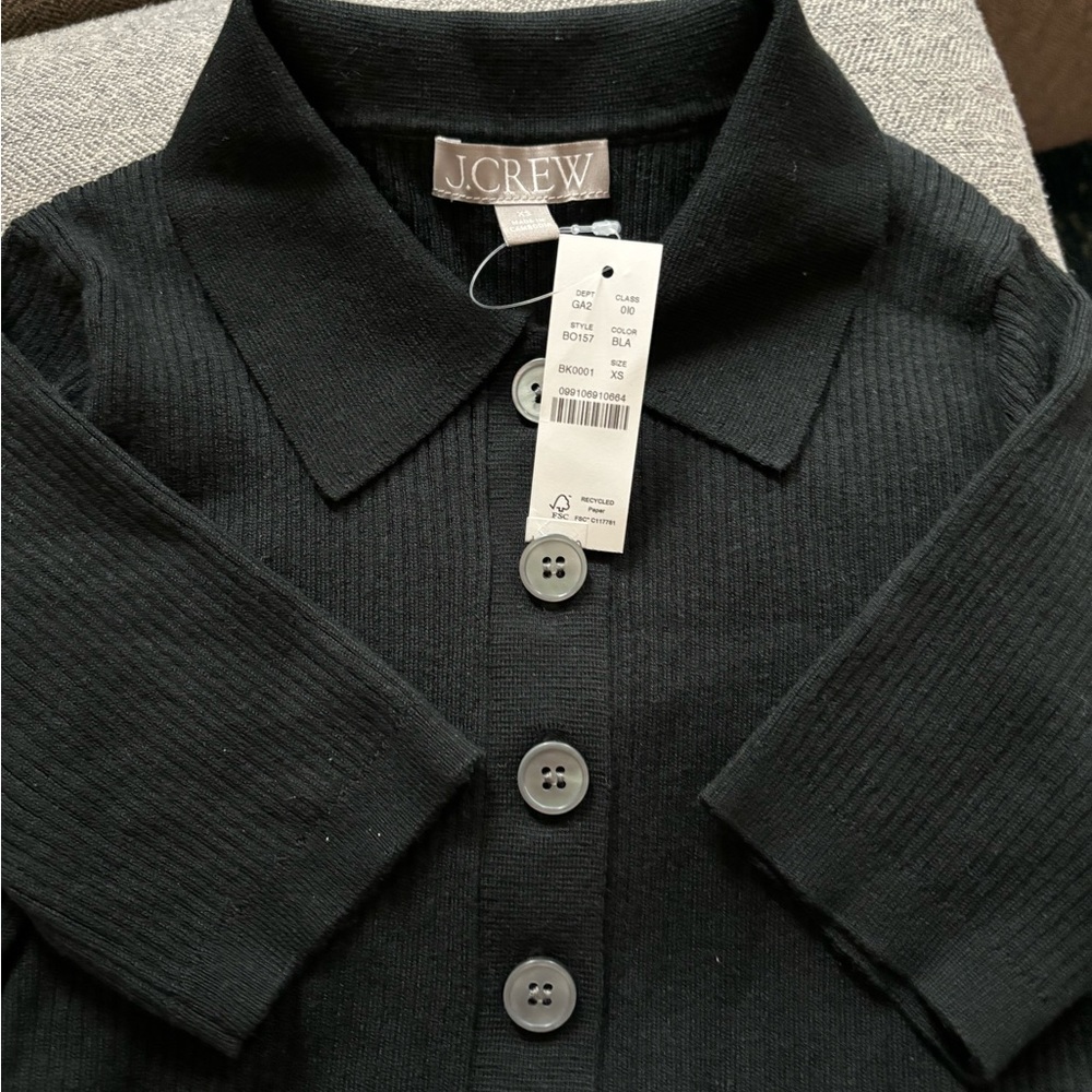 New, with tag, black ribbed short sleeved polo shirt.